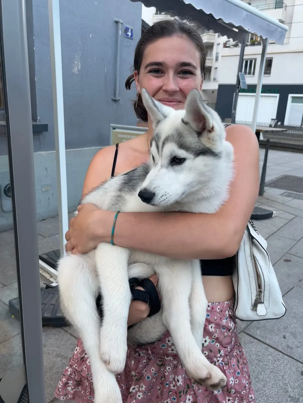 Kelly, pet sitter à Lyon, tenant un chiot husky dans ses bras